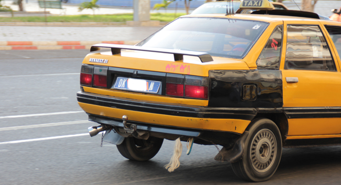 Many taxis and some private vehicles have some horsehair and a foot of children's footwear attached to the rear underside of the vehicle. It is said that the belief is that the paraphernalia helps to prevent accident, when increasing the speed of the vehicle... (IWN photo) 