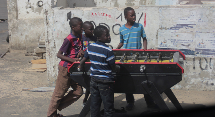 Children play table football at a roadside in Dakar. (IWN photo)