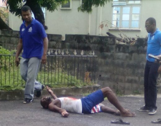 Police prepare to transport then wounded man to hospital. He died sometime after leaving the scene.
