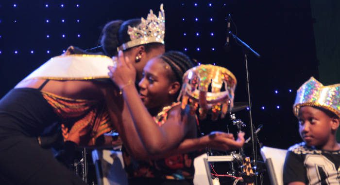 Primary School Calypso Monarch, Kristian Chritsopher, right, looks on as his sister, Junior Soca Monarch Kristiana Christophers crown falls as she is congratulated by Miss SVG 2016, Nikianna Williams, after Tuesdays competition. (IWN photo)