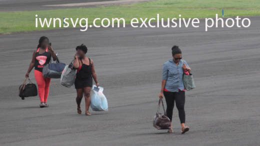 Desrey Vernice Stowe, right, and other passengers walk across the apron after landing at the E.T. Joshua Airport on Wednesday. (IWN photo)