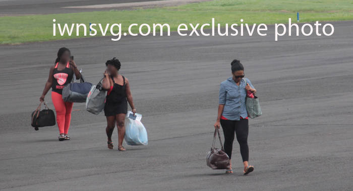 Desrey Vernice Stowe, right, and other passengers walk across the apron after landing at the E.T. Joshua Airport on Wednesday. (IWN photo)