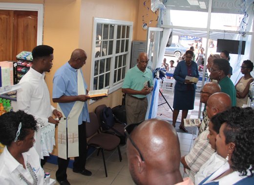 Deacon Victor Peters blesses the pharmacy on Bay Street, Kingstown on Saturday. (IWN photo)