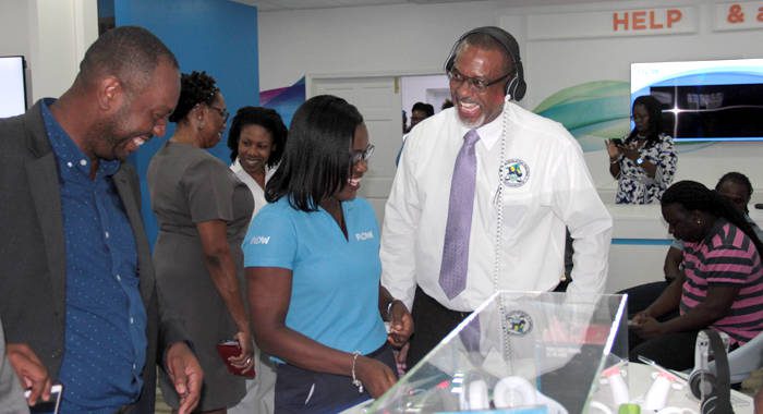 FLOW employee Maria DeGrads, centre, treats Director of Public Prosecution, Colin Williams, right, to an experience at the new FLOW store on Monday. (IWN photo)