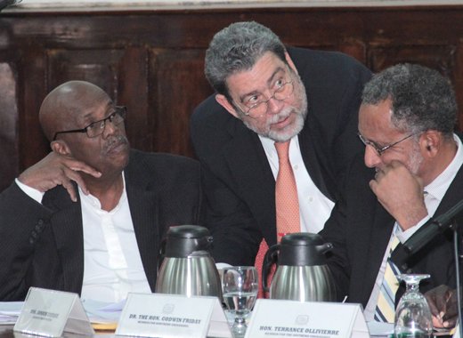 Prime Minister Dr. Ralph Gonsalves, centre, speaks with Opposition Leader Arnhim Eustace, left, and VP of the NDP, Dr. Godwin Friday, during the debate of the Cybercrime Bill on Thursday. (IWN photo)