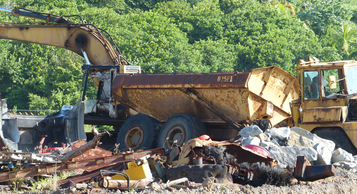 Derelict vehicle among a pile of garbage at Argyle International Airport. 