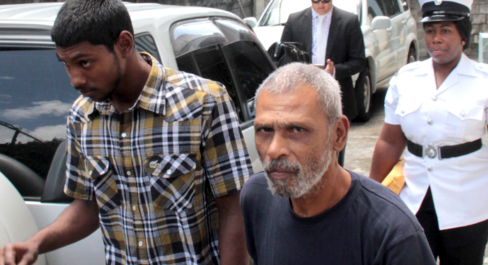The two Trinidadians walk towards a police transportaiton after exiting the Serious Offences Court in Kingstown. (IWN photo)