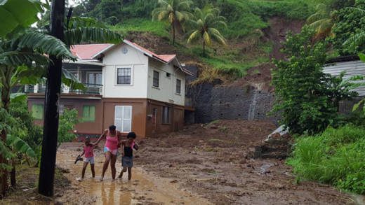 Persons walk pass the area of a landslide in Lowman Windward on Thursday. (Photo Saboto S. Caesar/Facebook)