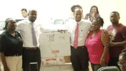 Sen. Carlos James and Minister of Health, Sen. Luke Browne, centre, make donation to family nurse practitioner, Judy Haywood, 2nd from right, Senior Nursing Officer Cecile James-Samuel, left, and Chateaubelair district doctor, Francis Murray -- at right.
