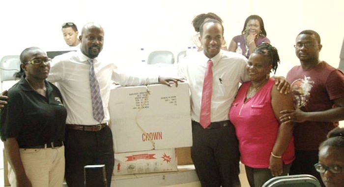 Sen. Carlos James and Minister of Health, Sen. Luke Browne, centre, make donation to family nurse practitioner, Judy Haywood, 2nd from right, Senior Nursing Officer Cecile James-Samuel, left, and Chateaubelair district doctor, Francis Murray -- at right.