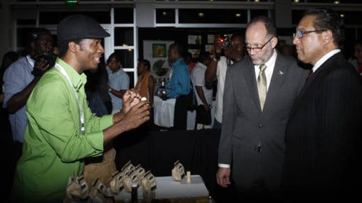 Haitian Jean-Sebastien Duvilaire, left, of Tahomey shows off one of his products to Secretary General of CARICOM, Irwin LaRocque, centre, and Premier of the Cayman Islands, Alden McLaughlin at Caribbean Week of Agriculture 2016 Agriculture MarketPlace in Grand Cayman on Oct. 26. (Photo: Kenton X. Chance)