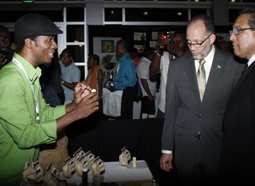 Haitian Jean-Sebastien Duvilaire, left, of Tahomey shows off one of his products to Secretary General of CARICOM, Irwin LaRocque, centre, and Premier of the Cayman Islands, Alden McLaughlin at Caribbean Week of Agriculture 2016 Agriculture MarketPlace in Grand Cayman on Oct. 26. (Photo: Kenton X. Chance)