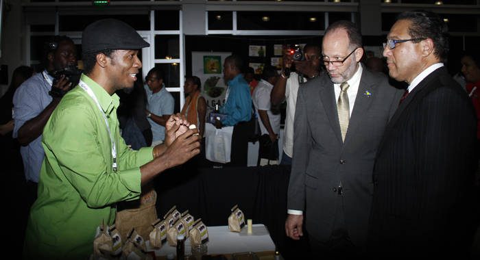 Haitian Jean-Sebastien Duvilaire, left, of Tahomey shows off one of his products to Secretary General of CARICOM, Irwin LaRocque, centre, and Premier of the Cayman Islands, Alden McLaughlin at Caribbean Week of Agriculture 2016 Agriculture MarketPlace in Grand Cayman on Oct. 26. (Photo: Kenton X. Chance)