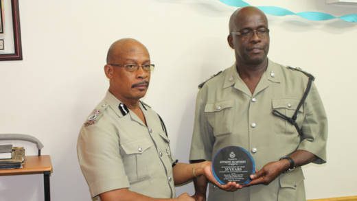 ASP Anthony Humphrey, right, receives a plaque from acting Commissioner of Police, Renold Hadaway. (Police photo)