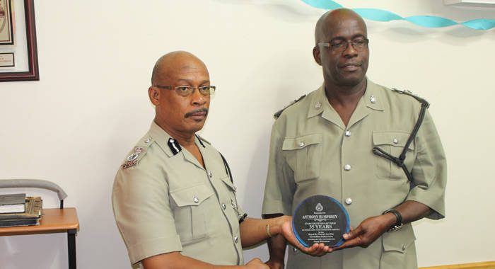 ASP Anthony Humphrey, right, receives a plaque from acting Commissioner of Police, Renold Hadaway. (Police photo)