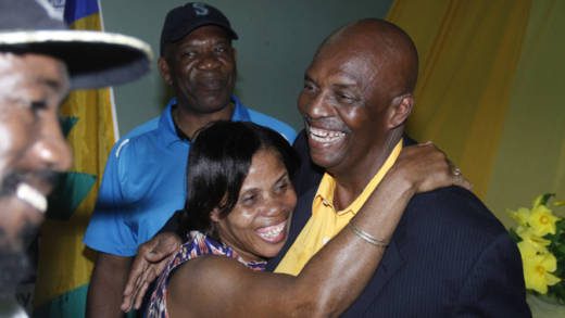 Outgoing president of the New Democratic Party, Arnhim Eustace, left, greets person after his speech Tuesday night. (IWN photo)
