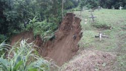 The landslide washed some graves into the river and exposed the contents of others. (IWN photo)