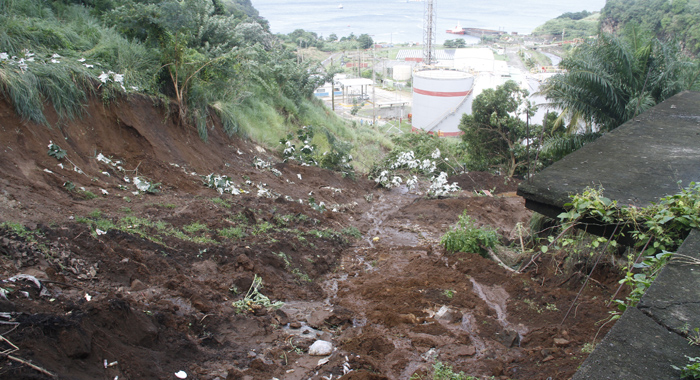 The landslide took the house several feet downslope, depositing it close to the fuel storage facility. (IWN photo)
