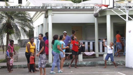 Scores of persons were forced into emergency shelters after their homes were destroyed. Here, some of them play basketball at the Sandy Bay Gov't School on Sunday. (IWN photo)