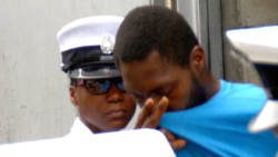 Keon Scott attempts to hide his face as he is led away from the Serious Offences Court on Tuesday. 