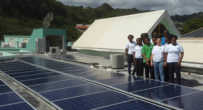 Some students of the SVGCC Environmental Club (2016-17) and the geography lecturer, Allanson Cruickshank, pose next to the solar panels.
