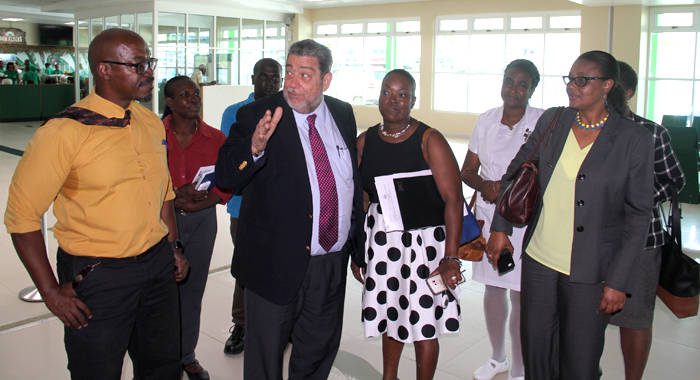 Prime Minister Ralph Gonsalves interacts with persons touring a tour of the terminal building of AIA on Wednesday. (IWN photo)