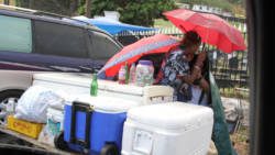 Icebox vendors shelter rain while waiting for sales at Kingstown Cemetery on Feb. 26, 2017. (iWN photo)