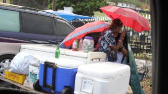 Icebox vendors shelter rain while waiting for sales at Kingstown Cemetery on Feb. 26, 2017. The government is moving to ban the possession, supply and consumption of alcohol during funeral possessions and at public cemeteries. (iWN photo)