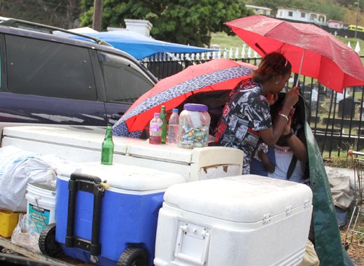 Icebox vendors shelter rain while waiting for sales at Kingstown Cemetery on Feb. 26, 2017. (iWN photo)