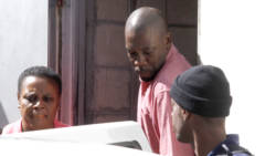 Murder accused Junior Jarvis, centre, is escorted by police as he leaves the Serious Offences Court of Friday. (iWN photo)