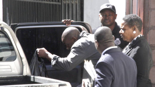 Junior Jarvis quickly enters a police vehicle after exiting the Serious Offences Court on Thursday. (iWN photo)