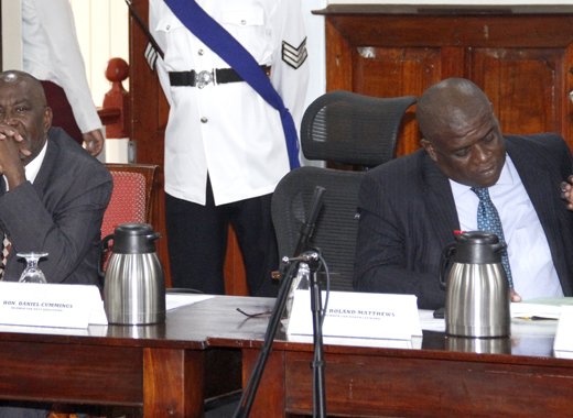A pensive Leacock, left, in Parliament as Matthew and Barnwell interact ahead of the Budget Speech on Monday. (iWN photo)