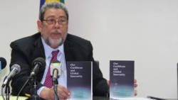 Prime Minister Dr. Ralph Gonsalves displays copies of the book at a press conference on Monday. (iWN photo)