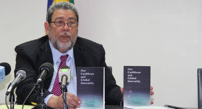 Prime Minister Dr. Ralph Gonsalves displays copies of the book at a press conference on Monday. (iWN photo)