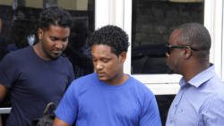 A detective escorts St. Lucians Mario Chtolie, left, and Aaron Kadoo at the Kingstown Magistrate's Court on Wednesday. (iWN photo)