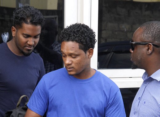 A detective escorts St. Lucians Mario Chtolie, left, and Aaron Kadoo at the Kingstown Magistrate's Court on Wednesday. (iWN photo)