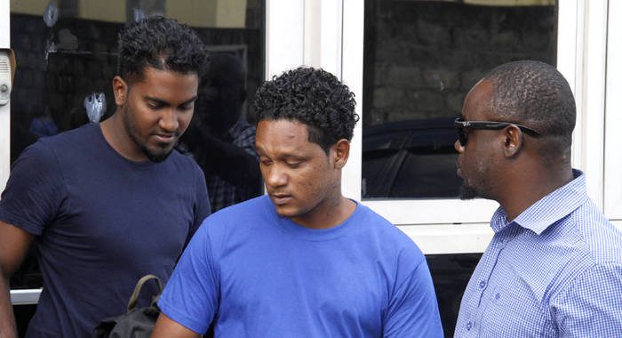 A detective escorts St. Lucians Mario Chtolie, left, and Aaron Kadoo at the Kingstown Magistrate's Court on Wednesday. (iWN photo)
