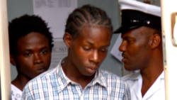 A police officer escorts Osbourne Rogers, left and Atibon Campbell from the Kingstown Magistrate's Court on Monday. 
