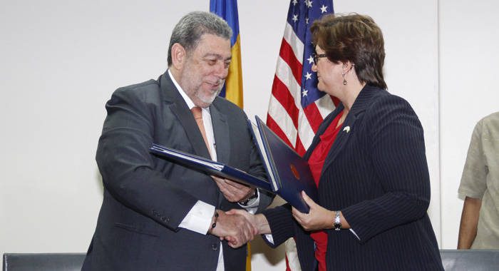 Prime Minister of SVG, Ralph Gonsalves, left, and Political Economic Director at U.S. Embassy in Bridgetown, Yaryna Ferencevyc, signed the agreement in Kingstown. (iWN photo)