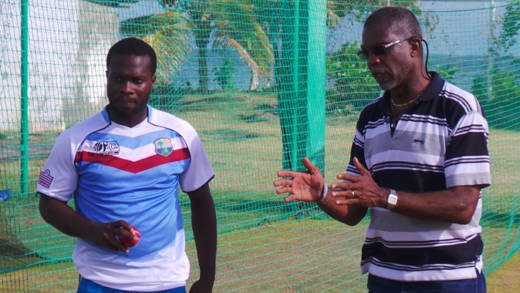 Holding gives some advice to former West Indies U19 pacer Ray Jordan.