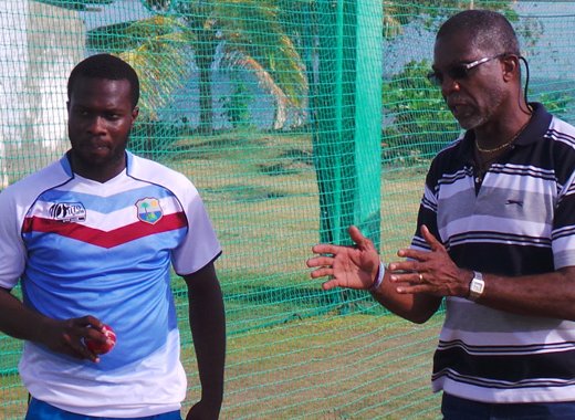 Holding gives some advice to former West Indies U19 pacer Ray Jordan.