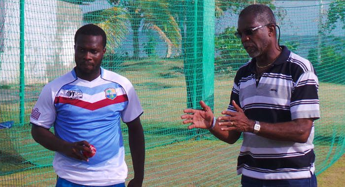 Holding gives some advice to former West Indies U19 pacer Ray Jordan.