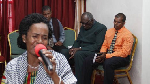 Simone Ballantyne leads worship in Fancy while Pastor Ehud Myers, centre, who was tried for the death if her daughter, sits on the platform. (iWN photo)
