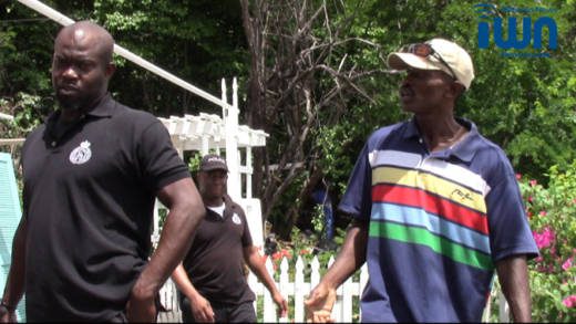 Otis Lockhart chats at his property on Friday with the police officers who arrested him on Monday. (iWN photo)