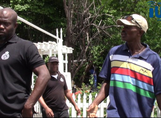 Otis Lockhart chats at his property on Friday with the police officers who arrested him on Monday. (iWN photo)