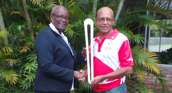 St. Lucia Sen. Fortuna Belrose, hands over the baton to NOC Chairman, Trevor Bailey.