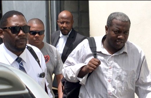 Charles, right, accompanied by Duncan, left, another detective, and his lawyer, leaves the court on Monday. (iWN photo)