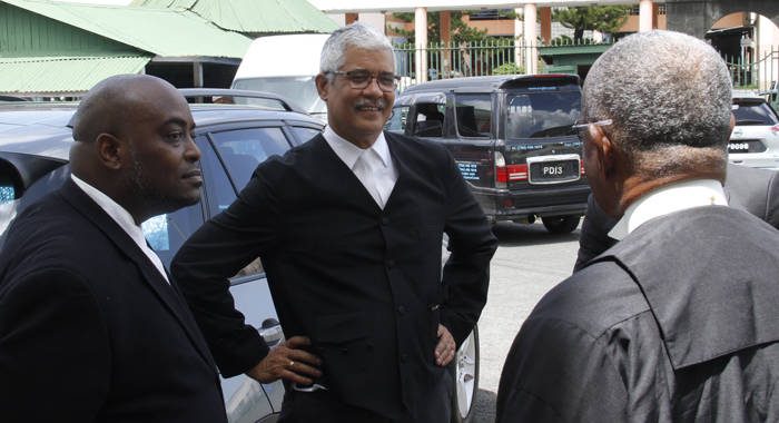 Antiguan Kendrickson Kentish, left and Trinidadian Douglas Mendez, chat with Vincentian Bertram Commissiong, QC outside the court on Wednesday. (iWN photo)