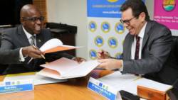 CTO Secretary-General Hugh Riley (left) and CDB President Dr. Warren Smith share a light moment during the signing of a partnership agreement at CDB headquarters. (Credit: Desmond Brown/IPS)