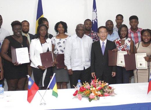 Ambassador Ger, in suit, and Minister of Education, Jimmy Prince pose with scholarship recipients on Monday. (iWN photo)